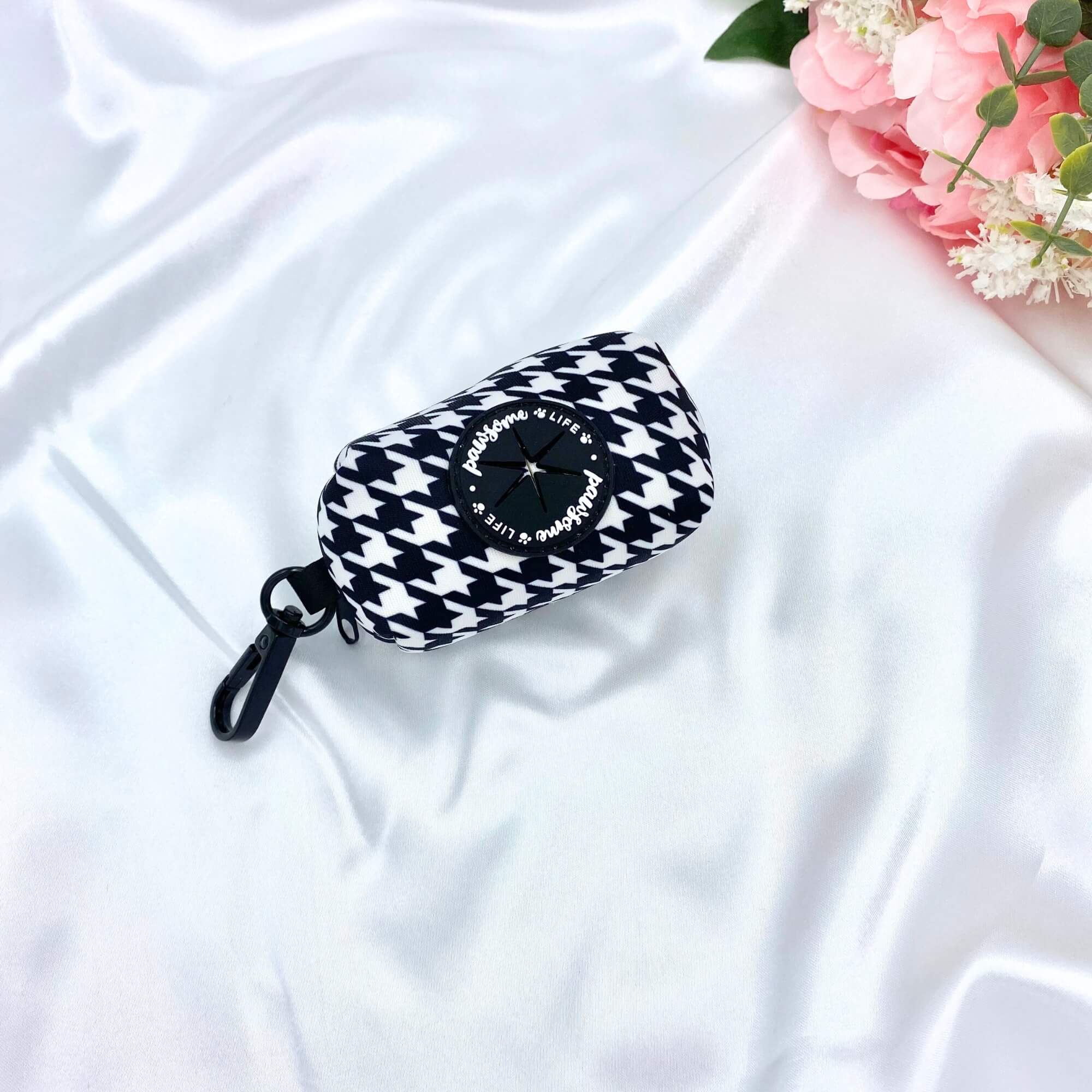 Cute dog poop bag holder with a classic houndstooth pattern and purple accents for stylish waste disposal