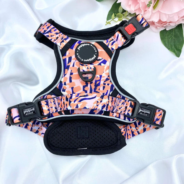Stylish dog harness with a trendy orange leopard print, perfect for fashionable walks