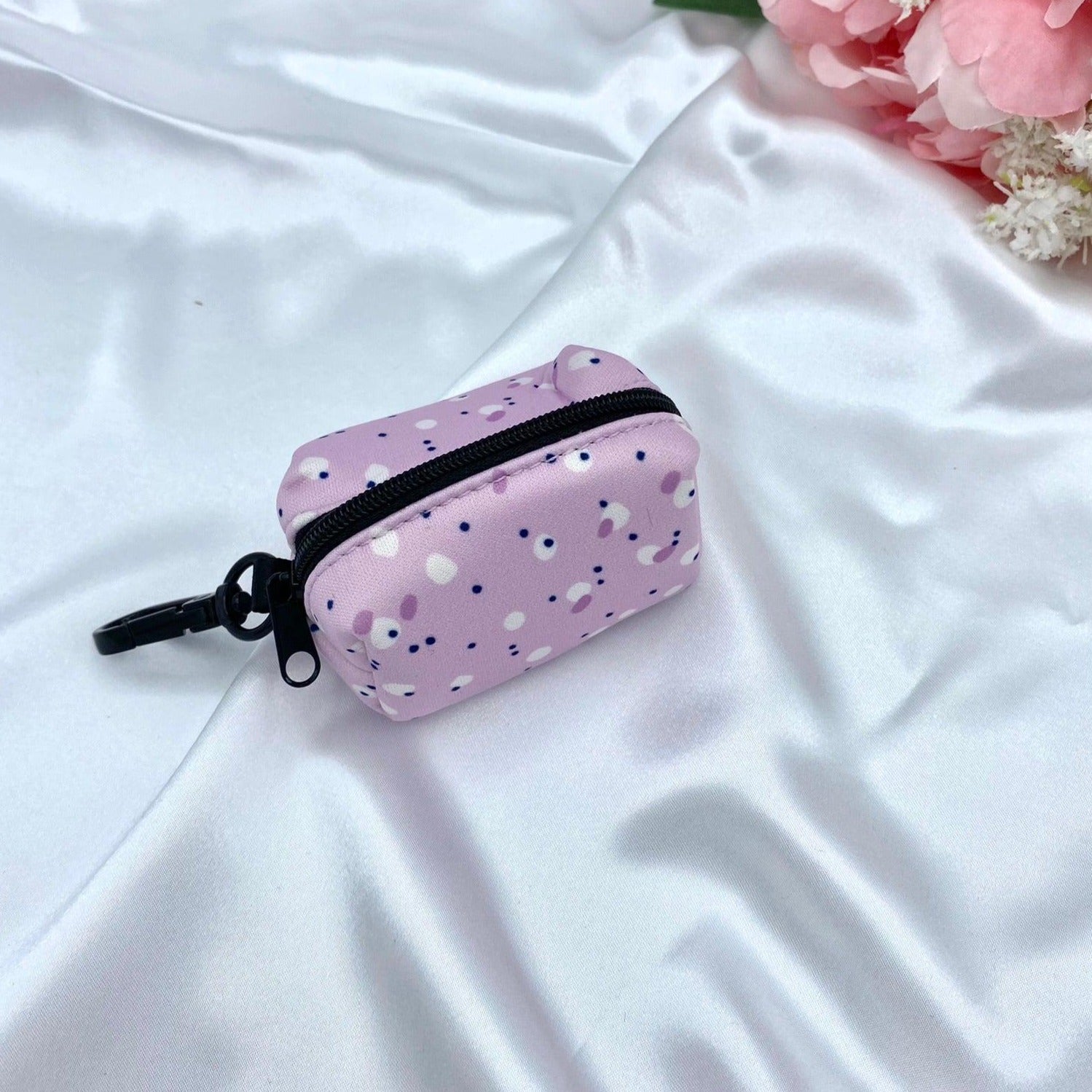 Designer dog waste bag holder with a playful pink, lilac, and purple pattern, blending style and functionality